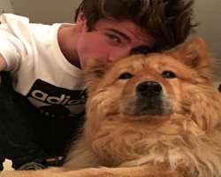 John is accompanied by a furry dog in his home.